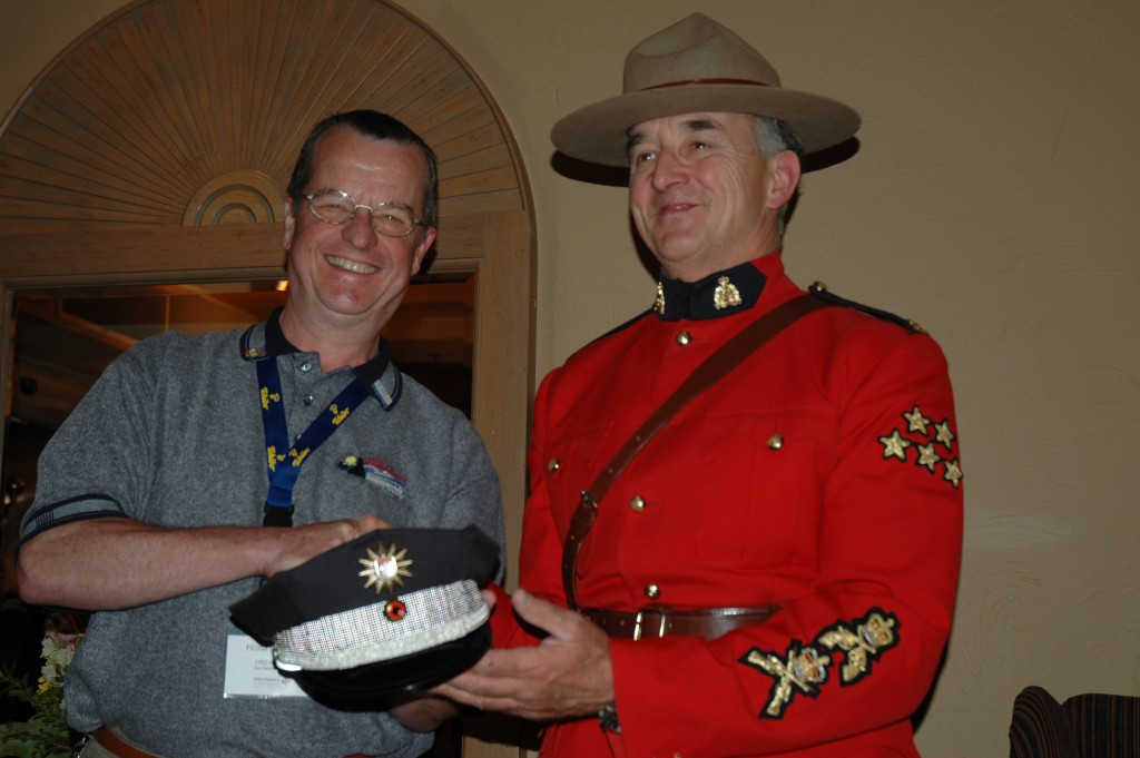 Horst Gennert presents an officer's hat of the Hamburg-Police to an RCMP officer in Calgary. The hat was provided by the Hamburg-Police public-realtions office. (Photo by Thorsten Ehrenberg)